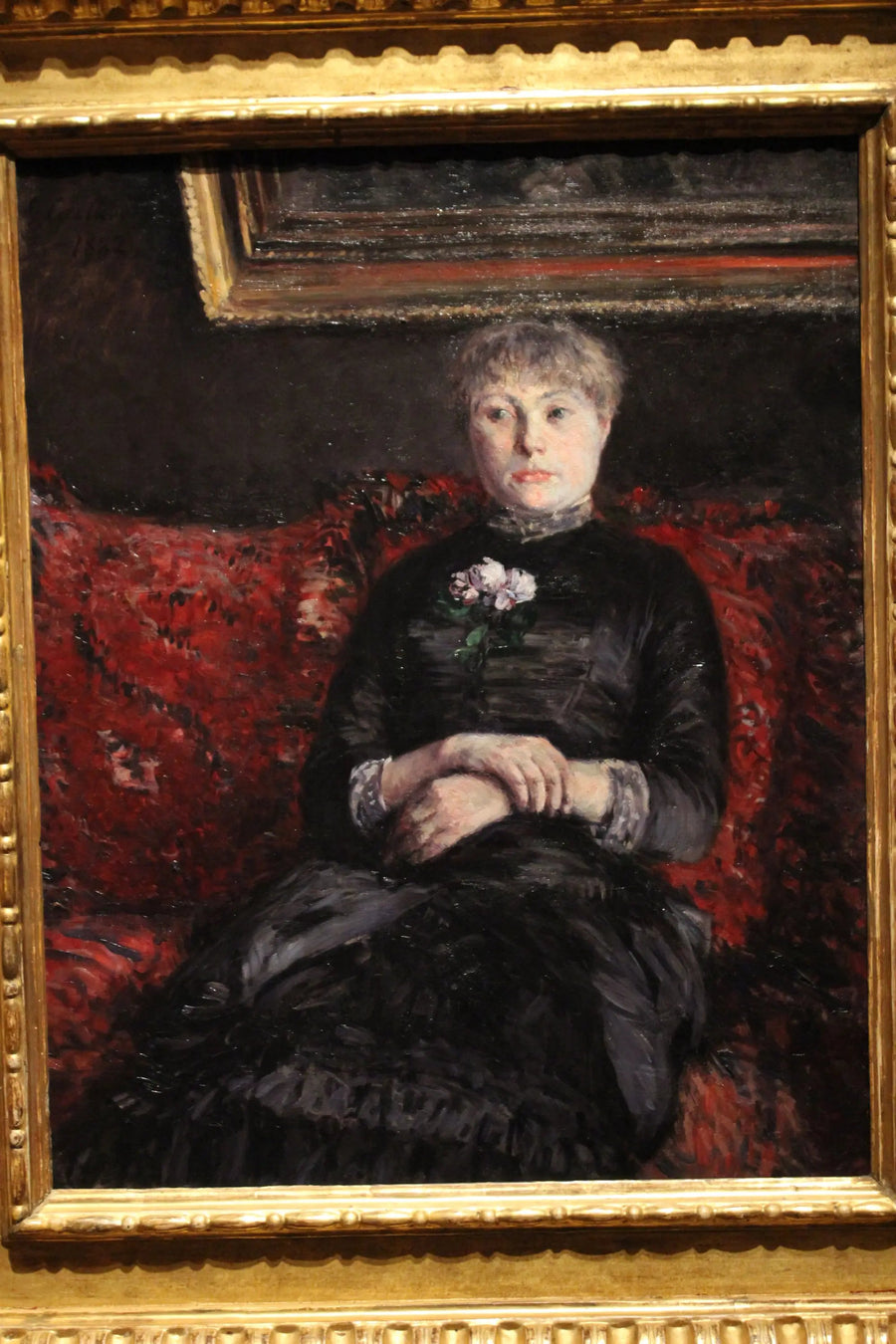 Donna seduta su un divano a fiori rossi - Gustave Caillebotte