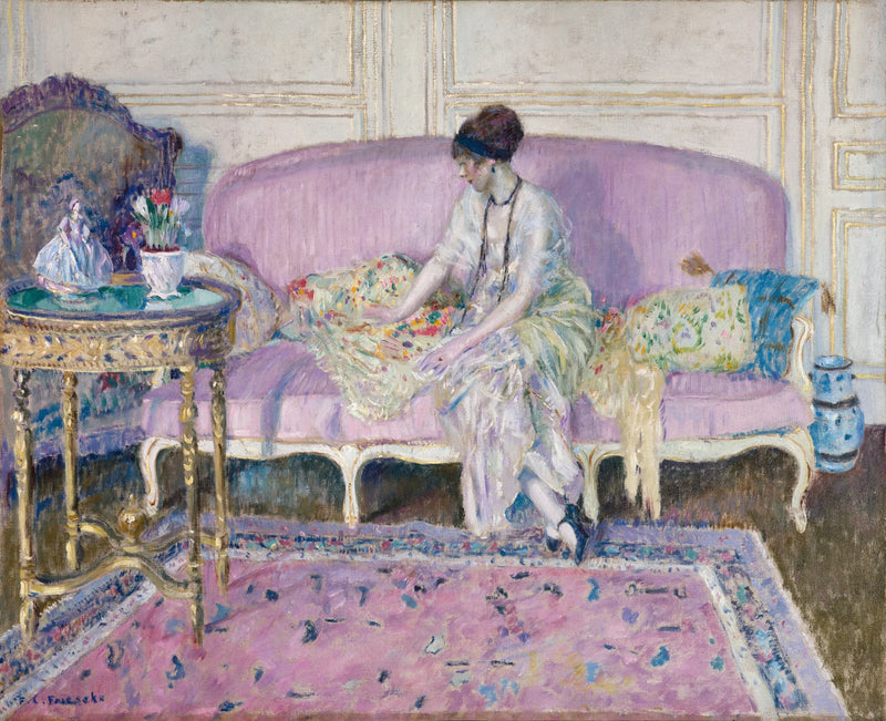 Donna seduta su un divano all'interno - Frederick Carl Frieseke